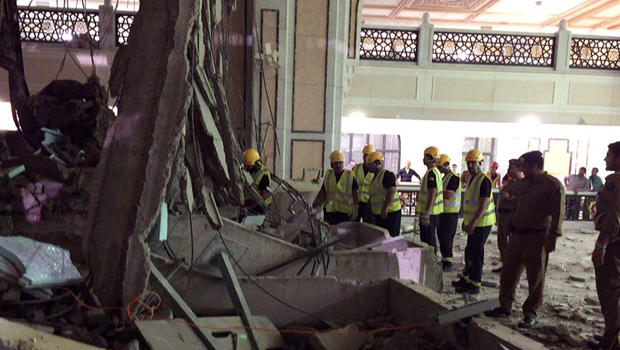 In this image released by the Saudi Interior Ministry's General Directorate of Civil Defense, Civil Defense personnel inspect the damage at the Grand Mosque in Mecca after a crane collapsed, killing dozens, Sept. 11, 2015. 