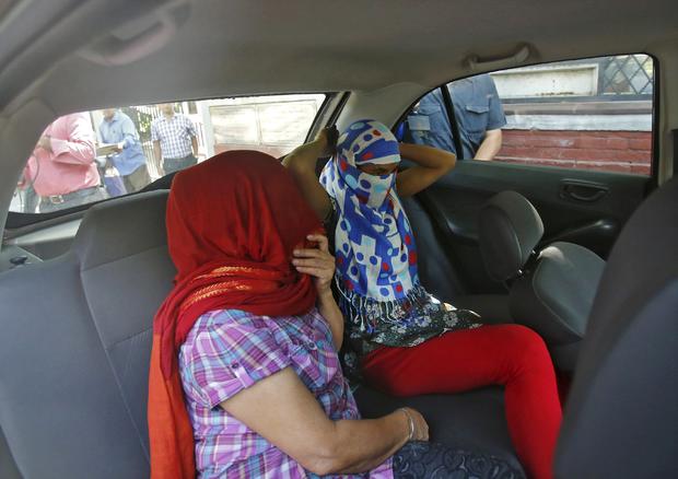 Two veiled Nepali women, who told police they were raped by a Saudi official, sit in a vehicle outside Nepal's embassy in New Delhi 