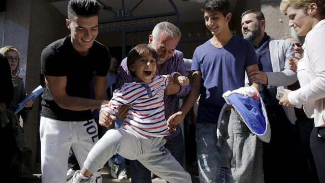 Osama Abdul Mohsen (center), a Syrian refugee who was tripped up by a camerawoman as he fled police in Hungary, with his young son Zaid and translator Mohamed Labrouzi (left) and his other son Mohammad al Ghadabe 