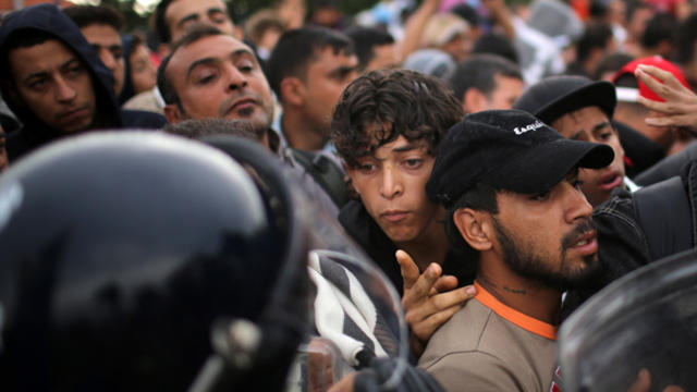 Migrants are held back by Slovenian riot police at the border in the small Croatian village of Harmica Sept. 19, 2015, in Harmica, Croatia. 