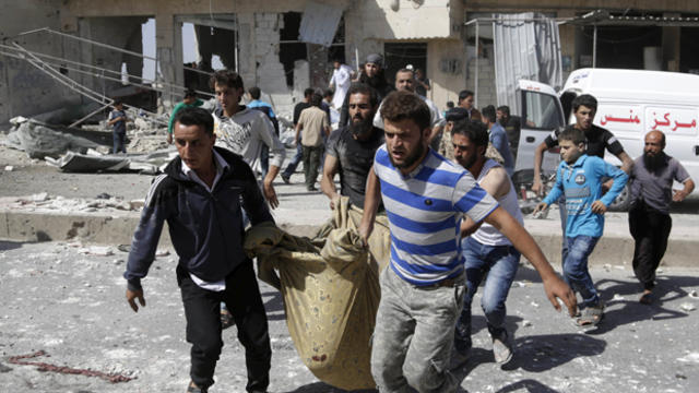 Men transport a dead body at a site hit by what activists said was an airstrike by forces loyal to Syria's President Bashar Assad in Kafruma village in the southern countryside of Idlib, Syria, Sept. 24, 2015. 