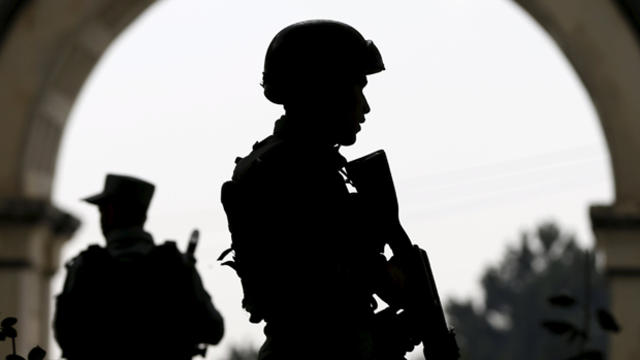 Afghan security forces stand guard near the main gate of Paghman district compound after a suicide bomb attack north of Kabul, Afghanistan, Sept. 16, 2015. 