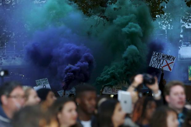 Demonstrators let off flares in the crowd during the Gala screening of the film "Suffragette" for the opening night of the British Film Institute (BFI) Film Festival at Leicester Square in London 