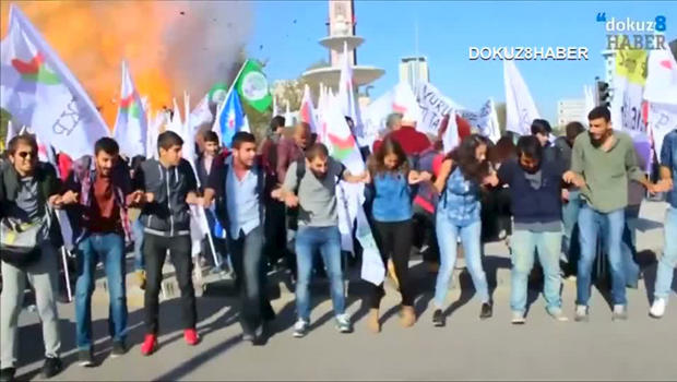 Protesters dance during a peace rally as a blast goes off in Ankara, Turkey, Oct. 10, 2015, in this still image taken from a video posted on a social media website. 
