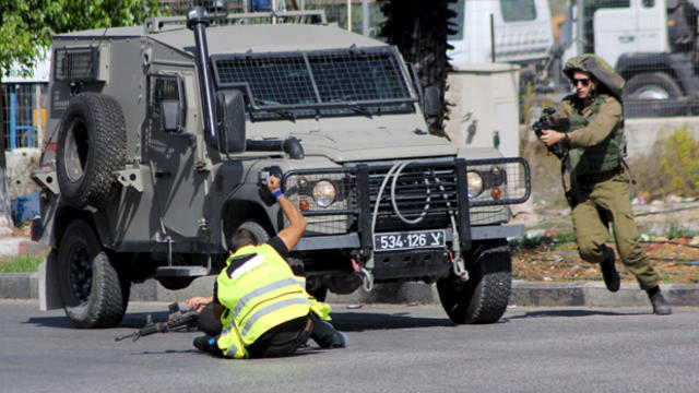 A Palestinian posing as a journalist stabs an Israeli soldier with a knife before being shot dead near the West Bank city of Hebron Oct. 16, 2015. 