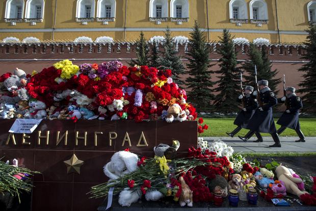 The Kremlin guards pass flowers and toys laid at the memorial stone with the word Leningrad (St. Petersburg) at the Tomb of the Unknown Soldier outside Moscow's Kremlin Wall in Moscow, Russia, Nov. 3, 2015. 