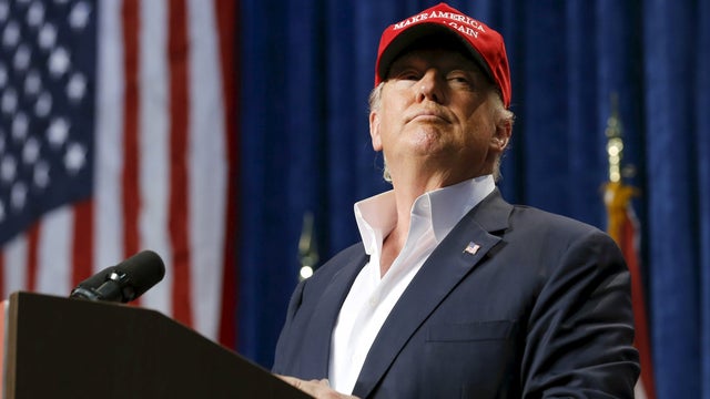 ​Republican presidential candidate Donald Trump watches as a member of the audience is removed from his rally in Sarasota, Florida, Nov. 28, 2015. 