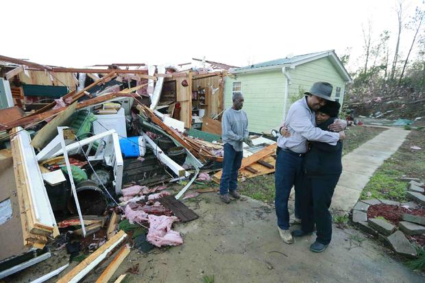 Phyllis Evans gets a hug from Harvey Payne early on December 24, 2015 after he stopped by to check on her and her home after a tornado struck Holly Springs, Mississippi 