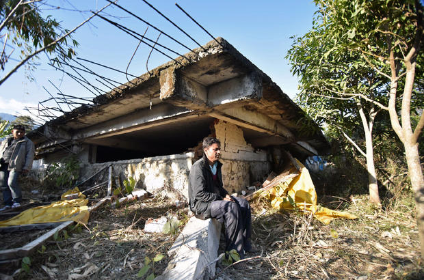 Gopal Motea sits in front of his collapsed house where his mother and daughter were killed in a 6.7 magnitude earthquake, in Leimakhong village on the outskirts of Imphal 