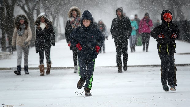 Schoolchildren run along the National Mall as snow begins to fall Jan. 22, 2016, in Washington, D.C. 
