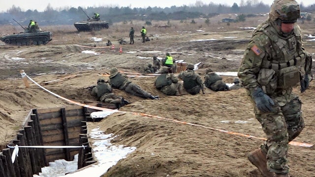 ​A U.S. military trainer moves out of the way as a platoon of Ukrainian soldiers prepare for "live fire" exercises at a training center near Ukraine's border with Poland 