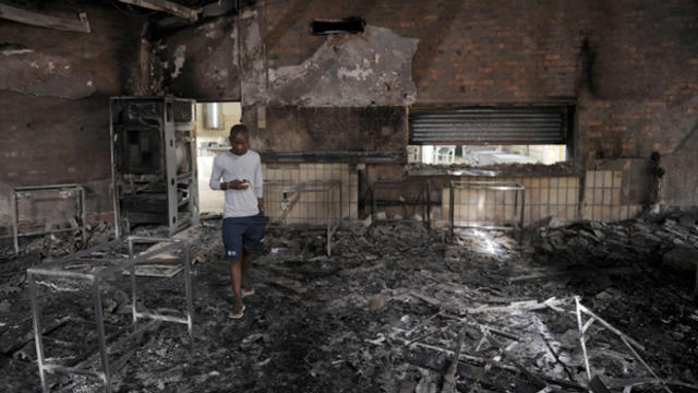 ​A student walks through the remains of the Science Center at the University of the North-West University in Mahikeng, South Africa, (also known as Mafikeng) Feb. 25, 2016. 