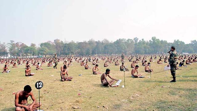 ​Job applicants take a written exam for clerical positions with the Indian army, in their underwear, in a field in the Muzaffarpur district of eastern India's Bihar state 