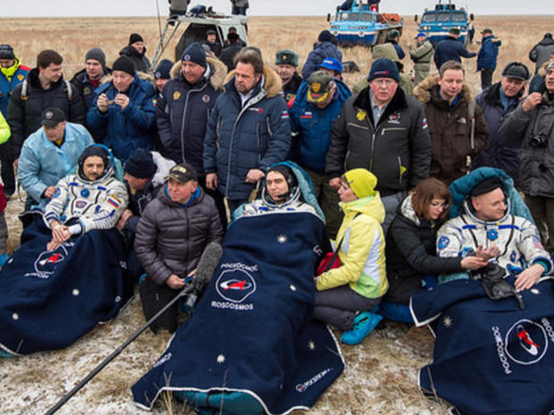 Cosmonaut Mikhail Kornienko, left, astronaut Scott Kelly, center, and spacecraft commander Sergey Volko, surrounded by ground crew members after returning to Earth, in Kazakhstan, on March 2, 2016 