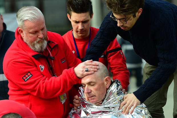 A victim receives first aid by rescuers on March 22, 2016, near the Maalbeek metro station in Brussels, Belgium, after an explosion near European Union institutions caused deaths and injuries. 