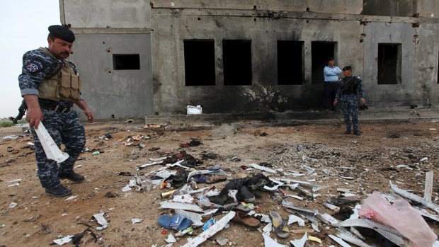 ​Iraqi security forces inspect the aftermath of a suicide bombing at a soccer field in Iskandariya, Iraq, March 26, 2016. 