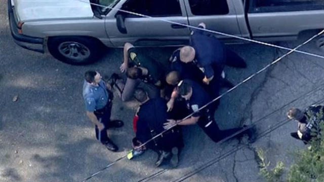 An image capture from helicopter video from CBS Boston shows police officers repeatedly punching a suspect after he was chased from Massachusetts into New Hampshire May 11, 2016.​ 