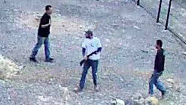 A still image taken from security video released by the National Park Service shows three men inside the perimeter fence at the edge of Devils Hole in Death Valley National Park, Nev., on April 30, 2016. 