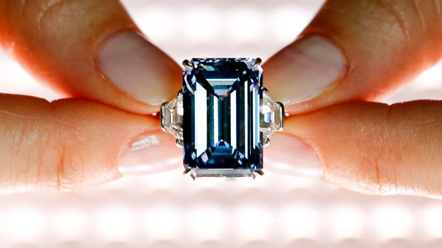 A Christie's employee poses with the 14.62 carats "Oppenheimer Blue" diamond during a preview in Geneva, Switzerland, on May 12, 2016. 