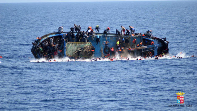 ​Migrants are seen on a capsizing boat before a rescue operation by Italian navy ships Bettica and Bergamini off the coast of Libya in this handout picture released by the Italian Marina Militare on May 25, 2016. 