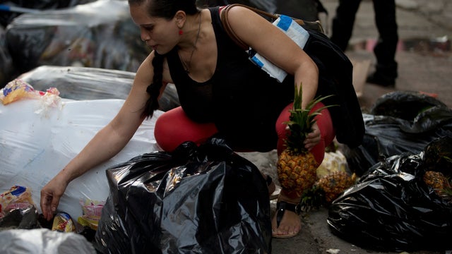 Venezuelans are forced to pick though trash heaps of rotten fruit and vegetables tossed out by nearby shops in order to eat,  
