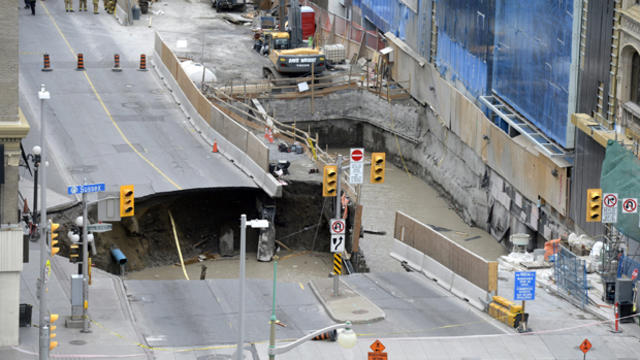 Water can be seen in a large sinkhole that formed on Rideau Street next to the Rideau Centre mall in Ottawa, Ontario, on June 8, 2016. 