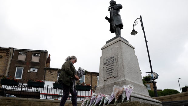 ​A woman arrives with flowers to leave in tribute to Jo Cox near the scene where she was killed in Birstall near Leeds, England, June 16, 2016. 