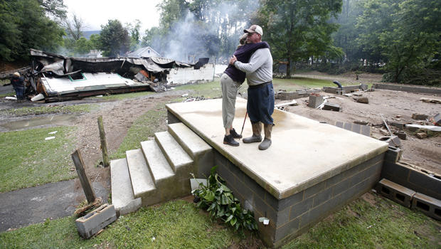 Jimmy Scott gets a hug from Anna May Watson, left, as they clean up from severe flooding in White Sulphur Springs, West Virginia, June 24, 2016. 