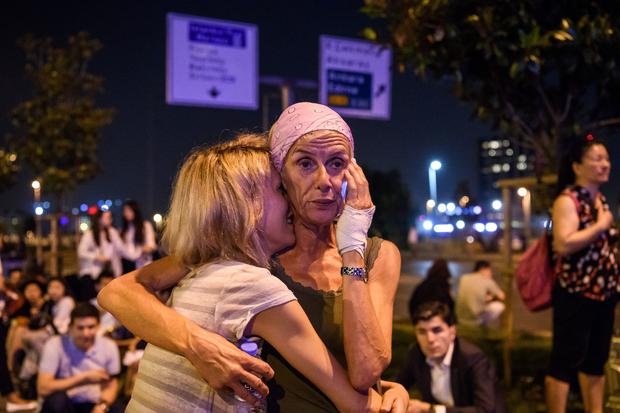 Passengers embrace outside main entrance of Ataturk Airport in Istanbul, Turkey on June 28, 2016, after blasts and gunfire left dozens dead and injured 