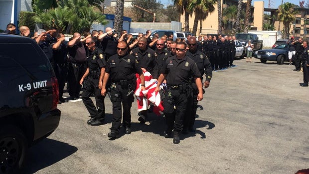 Officers with the Long Beach Police Department in California carry the remains of Credo, a police dog, after he was killed during a confrontation with a gunman on June 28, 2016. 