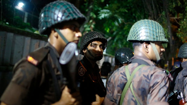 Bangladeshi security personnel stand guard near a restaurant that was attacked by gunmen in Dhaka, Bangladesh, on July 1, 2016. 
