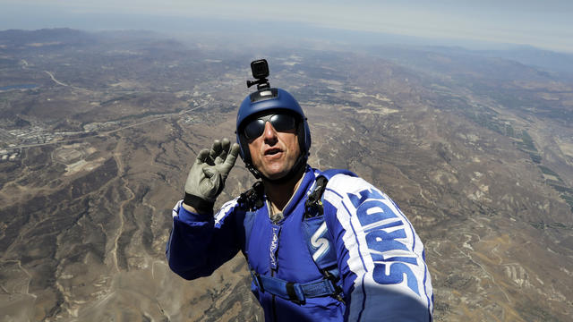 Skydiver Luke Aikins signals to pilot Aaron Fitzgerald as he prepares to jump from a helicopter in Simi Valley, Calif., July 25, 2016. 