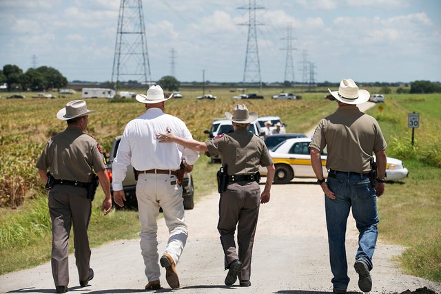 ​Texas Department of Public Safety Trooper Robbie Barrera, center right, puts her arm around Caldwell County Sheriff Daniel Law as he arrives on the scene of a hot air balloon crash July 30, 2016, near Lockhart, Texas, causing what authorities described a 