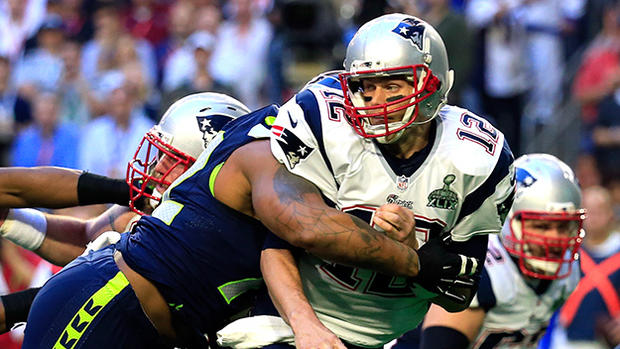 Tom Brady Hit By Michael Bennett - Super Bowl XLIX - New England Patriots v Seattle Seahawks 
