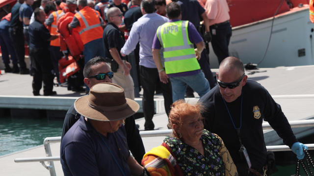 Passengers from the Caribbean Fantasy receive assistance after being rescued from their ship that was burning about two miles off of San Juan, Puerto Rico, Aug. 17, 2016. 