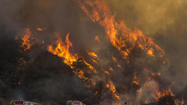 Flames spread up a hillside near firefighters at the Blue Cut Fire on Aug. 18, 2016, near Wrightwood, California. 
