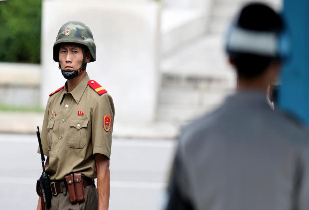 A North Korean soldier looks on as South Korean and United Nations officials visit after attending a ceremony to commemorate the 62nd Anniversary of the Korean War armistice agreement at Panmunjom on July 27, 2015, in South Korea. 