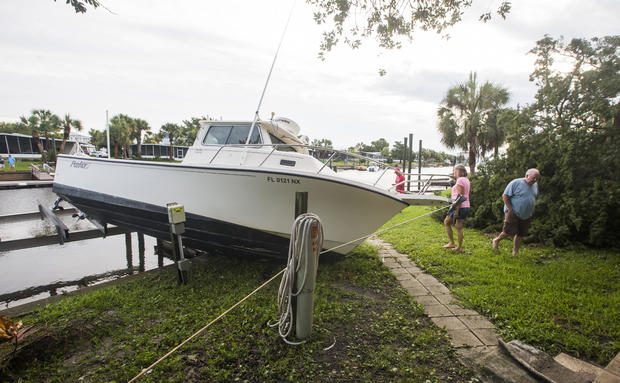 Residents check the damage to a boat in their neighborhood after Hurricane Hermaine came ashore on Sept. 2, 2016, in Shell Point Beach, Florida. 