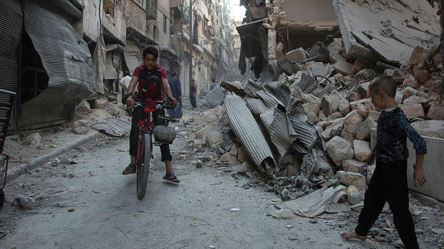 Syrian boys play amid rubble following an airstrike on Aleppo’s rebel-controlled neighbourhood of Karm al-Jabal 