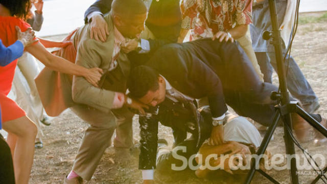 Sean Thompson, bottom, is tackled after hitting Mayor Kevin Johnson of Sacramento, California, with a pie at Sacramento Charter High School on Sept. 21, 2016. 