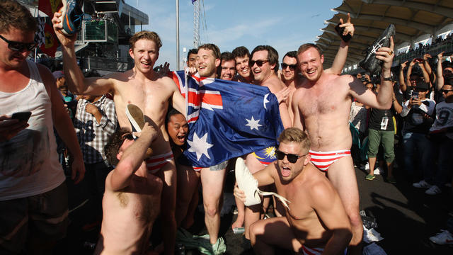 Australian men pose for a photo in Budgy Smuggler-brand swimsuits decorated with the Malaysian flag at the conclusion of the Malaysian Formula One Grand Prix 
