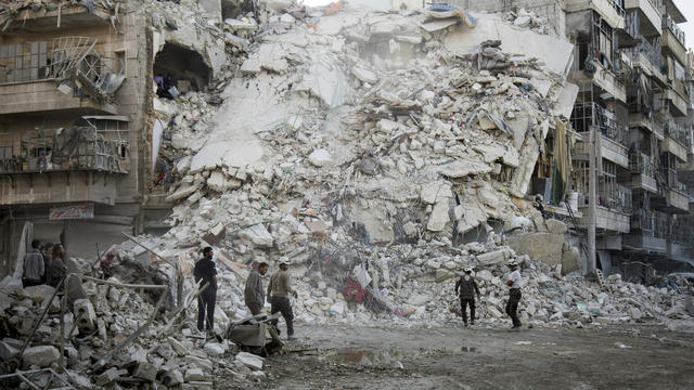 Members of the Syrian Civil Defence, known as the White Helmets, search for victims amid the rubble of a destroyed building following reported airstrikes in the rebel-held Qatarji neighborhood of the northern city of Aleppo, Syria, on Oct. 17, 2016. 