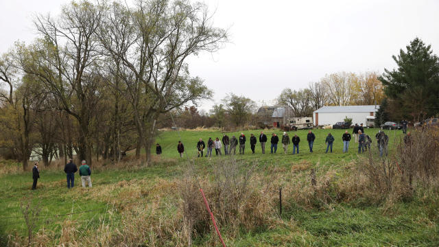 Investigators search a field near Redfield, Iowa, where the suspected gunman of two police officers who were shot and killed in separate attacks described as “ambush-style” in Urbandale and Des Moines, Iowa, turned himself in Nov. 2, 2016. 