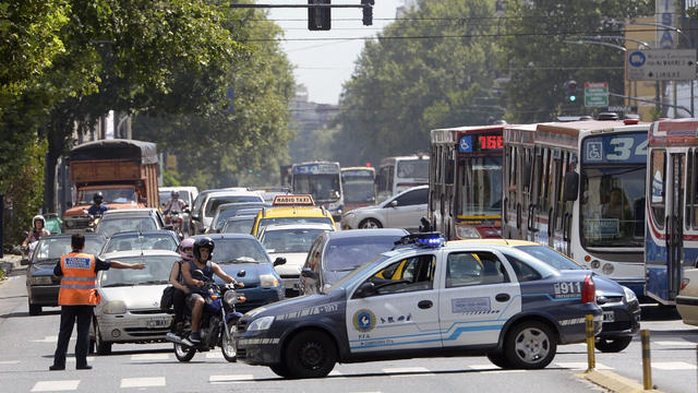 A police patrol car blocks Juan B. Justo Avenue in Buenos Aires during a protest by people affected by power outages on Dec. 30, 2013. 