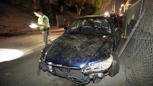 A California Highway Patrol investigator views the scene where a car went off the side of the southbound lanes of Interstate 405 and landed on a homeless encampment in the Van Nuys area of Los Angeles Nov. 29, 2016. 