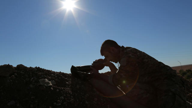 A Syria Democratic Forces fighter looks through a scope near the town of Tel al-Saman in the northern rural area of Raqqa, Syria, Nov. 17, 2016. 
