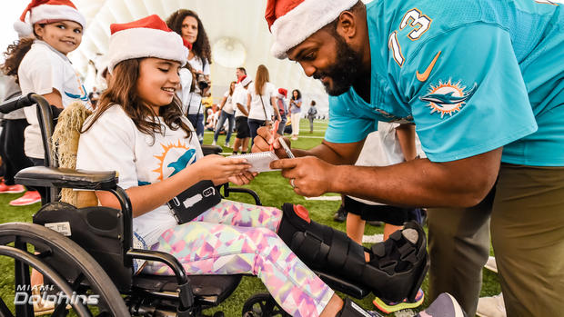 julius-warmsley-with-students-at-the-dolphins-holiday-toy-event.jpg 