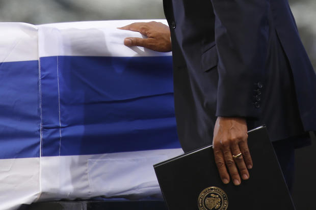 President Obama touches the flag-draped coffin of former Israeli President Shimon Peres during his funeral at the Mount Herzel national cemetery in Jerusalem, Sept. 30, 2016. 