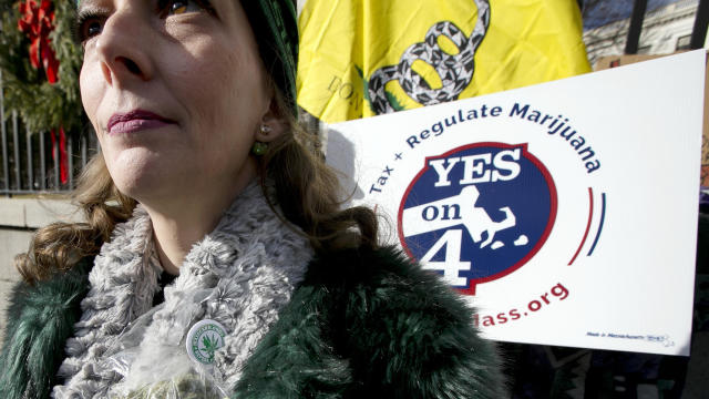 With marijuana pinned to her scarf, RachelRamone Donlan attends a rally in front of the Statehouse in Boston Dec. 30, 2016. The small group of protesters were objecting to any delay in opening retail marijuana stores in Massachusetts. 