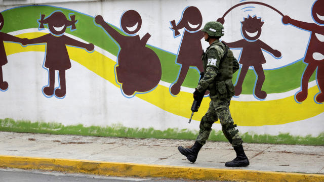 A soldier walks near the Colegio Americano del Noreste after a student opened fire at the American school in Monterrey, Mexico, Jan. 18, 2017. 